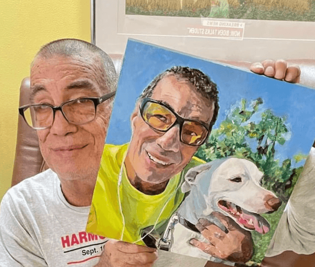 A man holding a painting made by Roberta Durra
